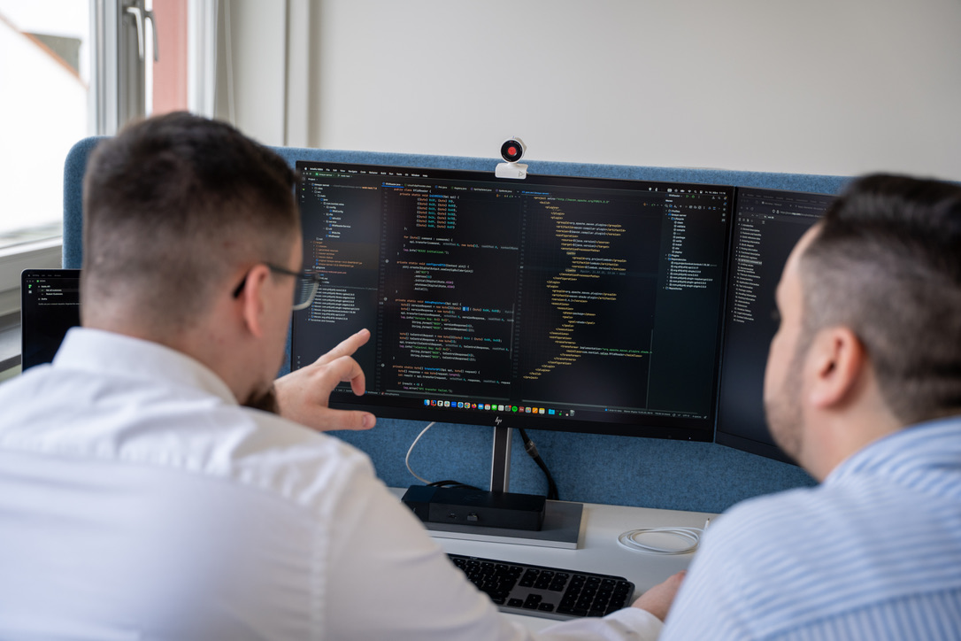 Zwei Entwickler der Kontial GmbH bei der gemeinsamen Arbeit am Code
